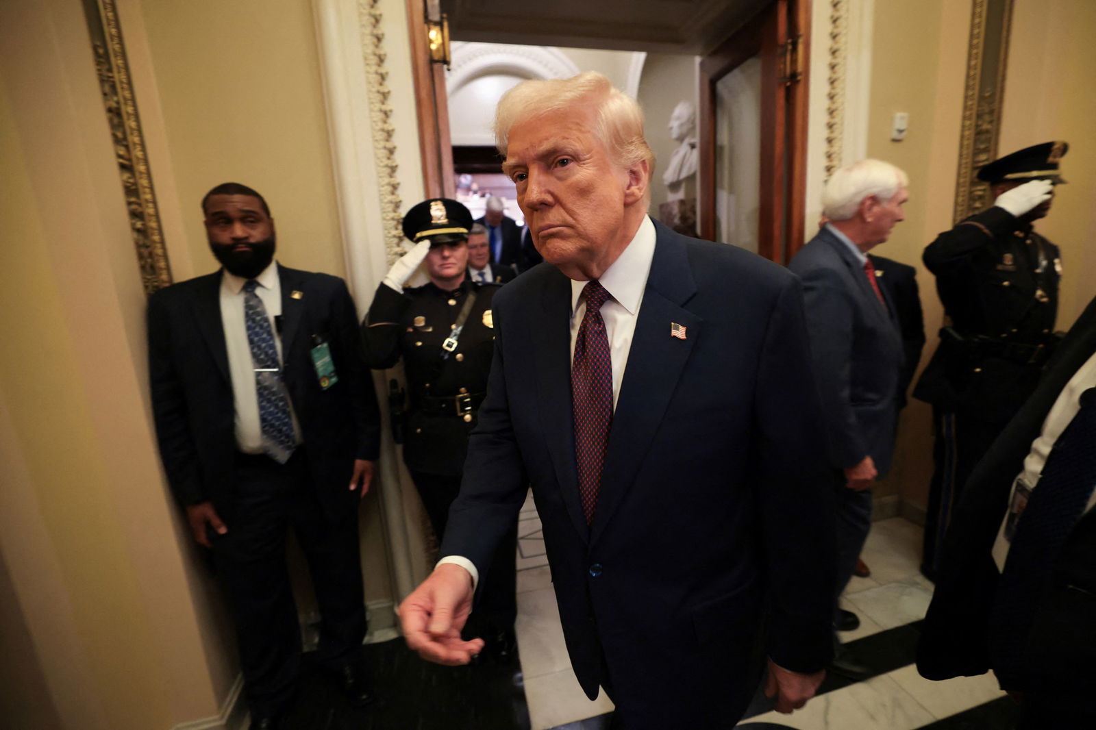 Donald Trump walks through a corridor.