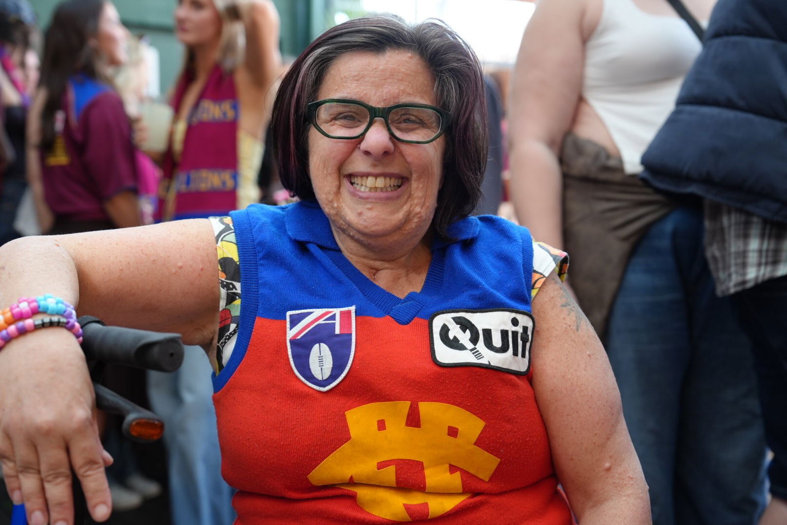 Marianne beams, sitting in a crowded pub, dressed in Brisbane Lions gear.