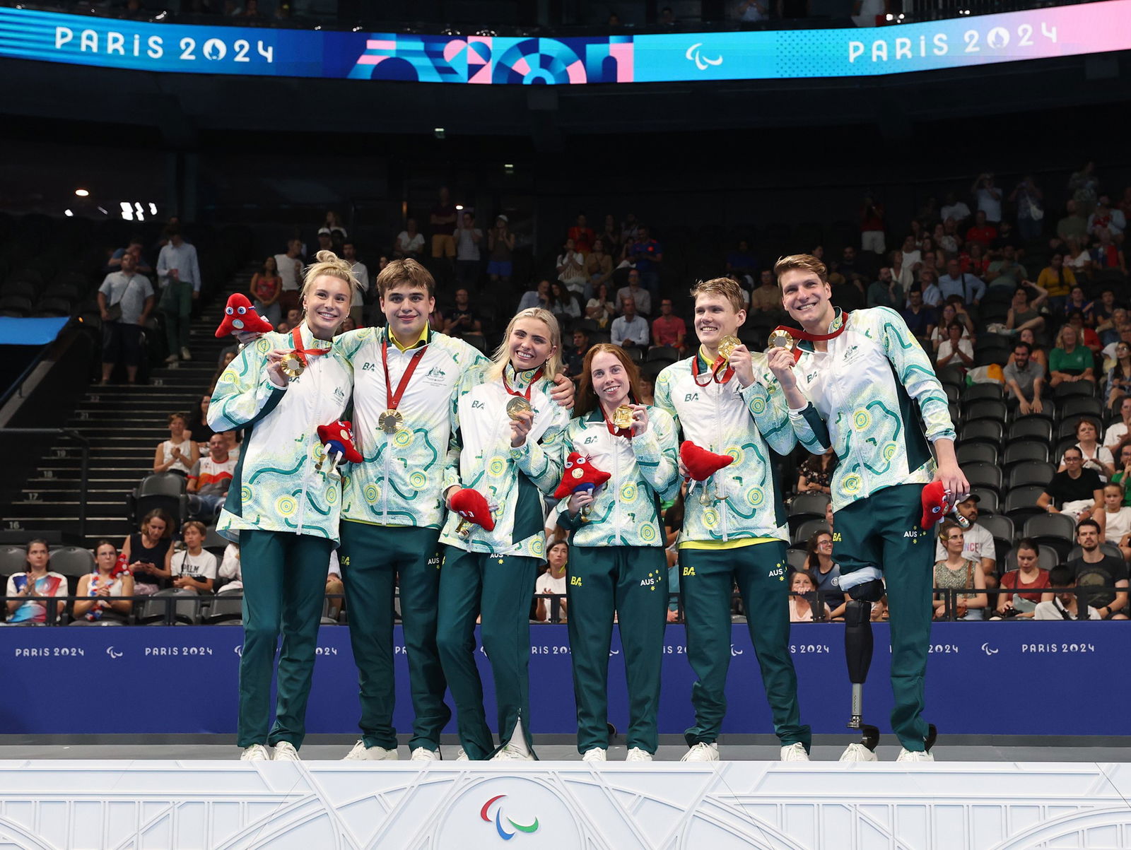 Australia's mixed 4x100m medley relay team celebrates on the podium.