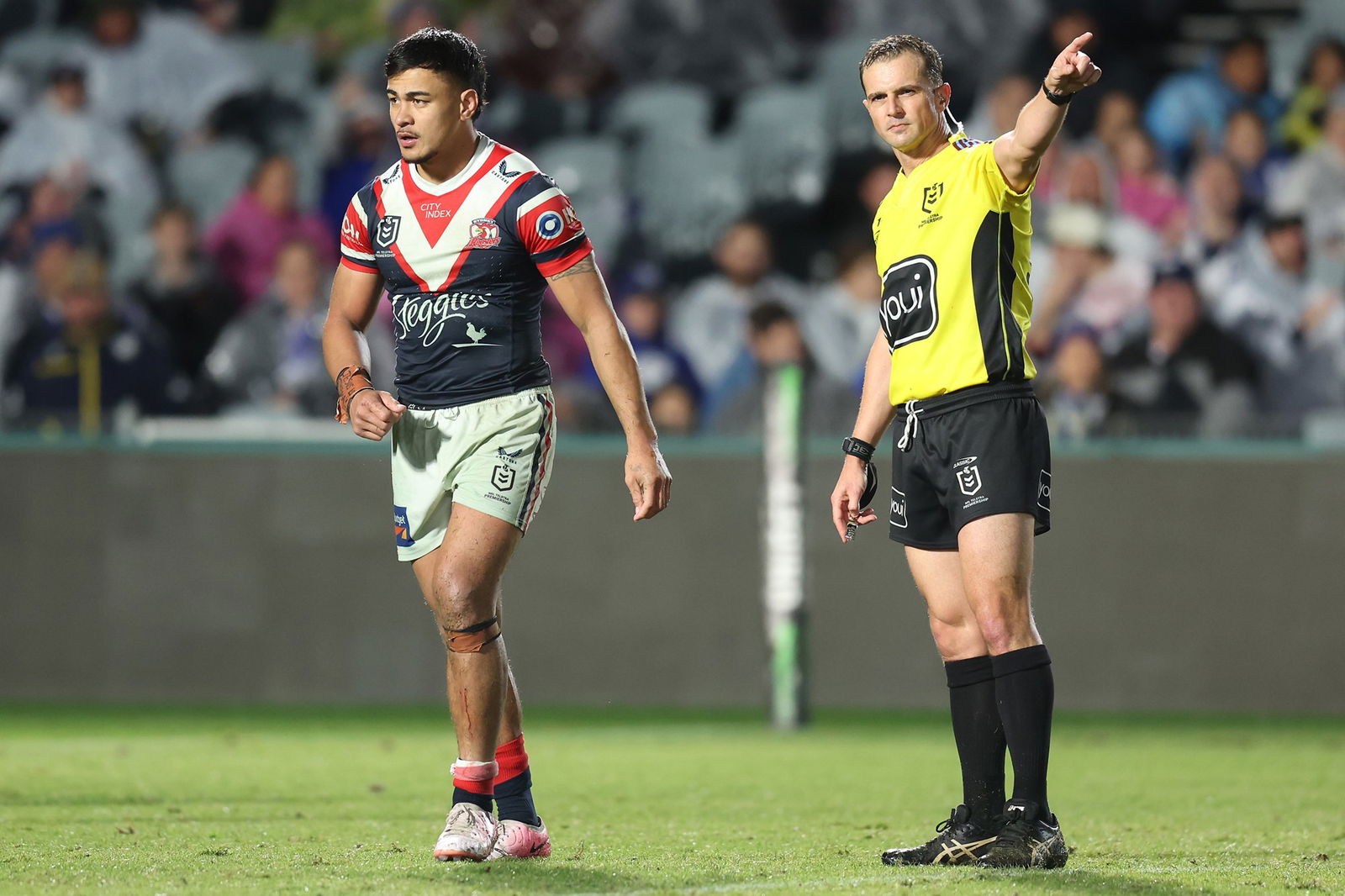 Sydney Roosters player Fetalaiga Pauga walks off the field as the referee points to the sideline.