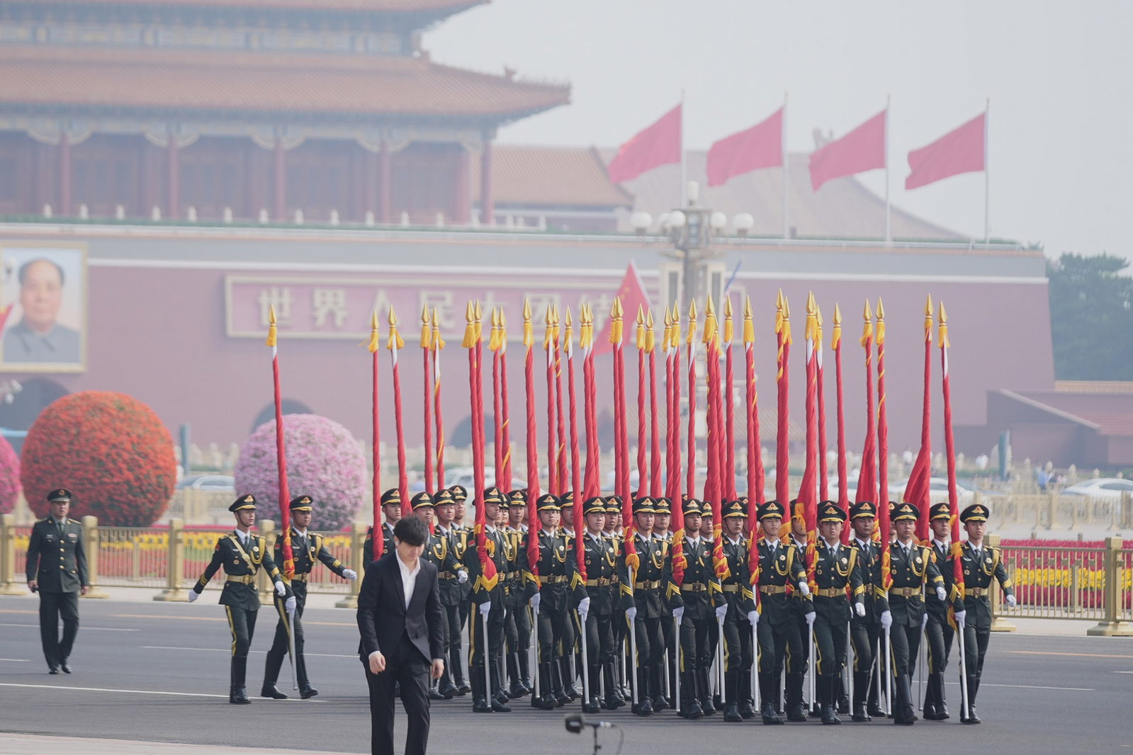 Several men in military uniforms holding red glags.