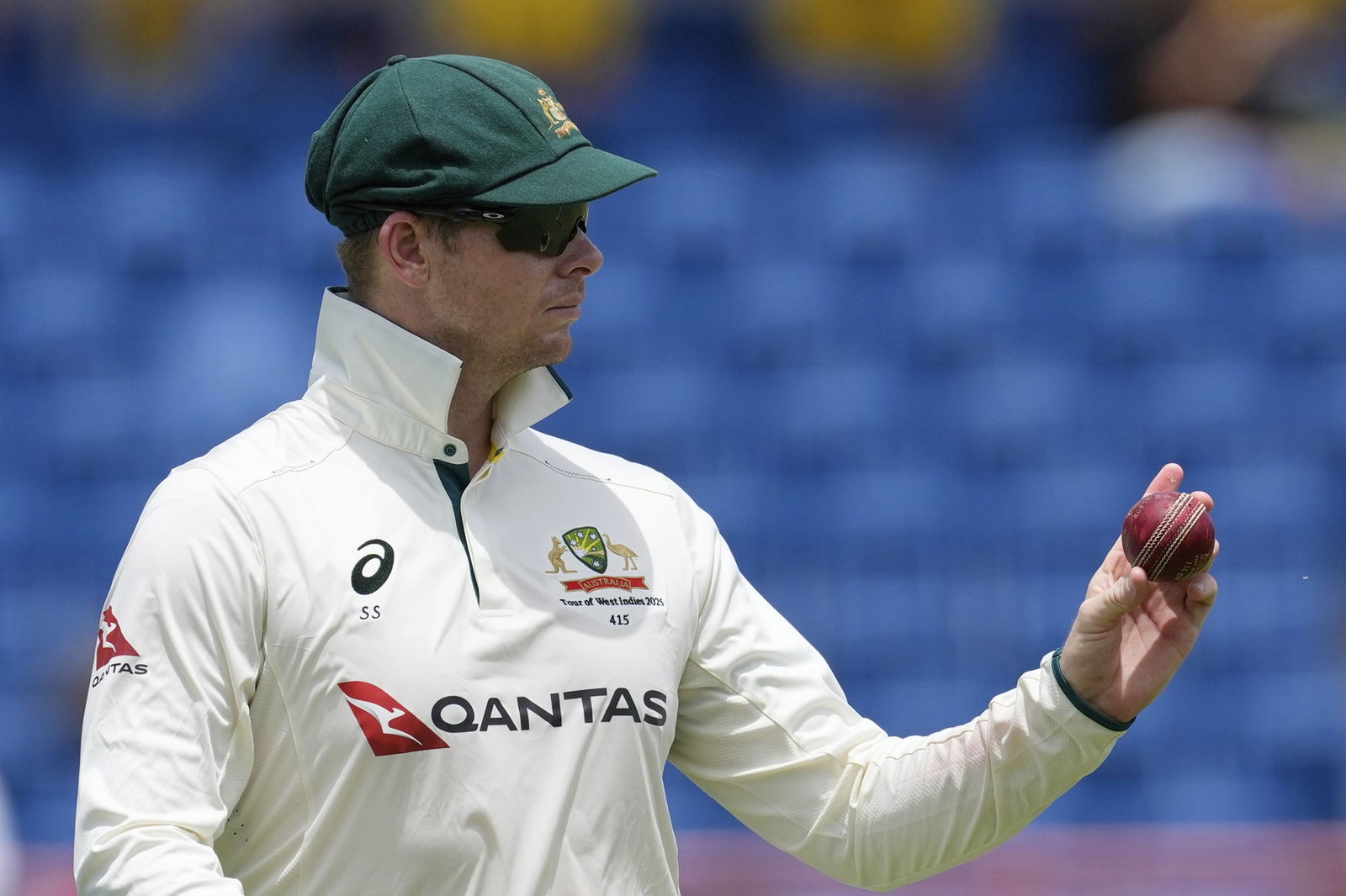 Steve Smith looks at a cricket ball he's holding.