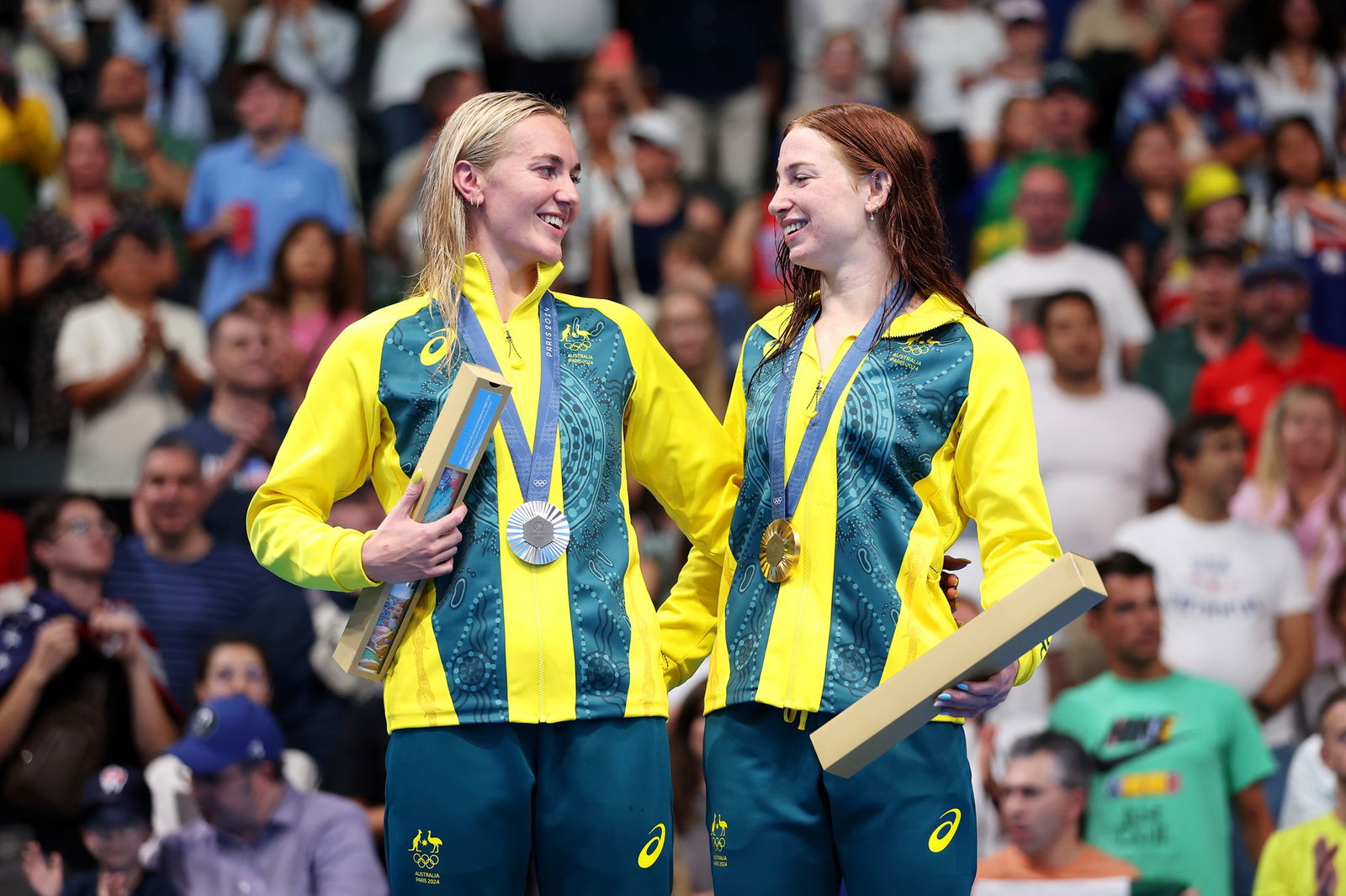 Ariarne Titmus and Mollie O'Callaghan celebrate on the podium after the women's 200m freestyle final.