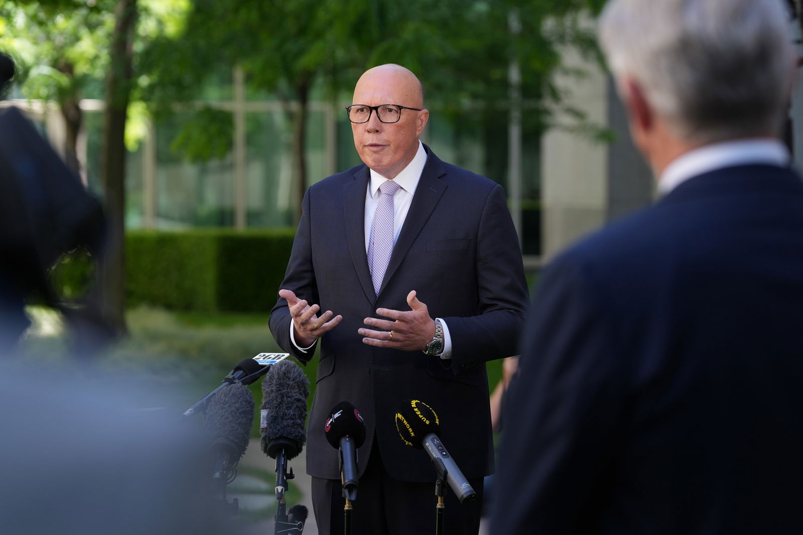 Peter Dutton stands in front of microphones