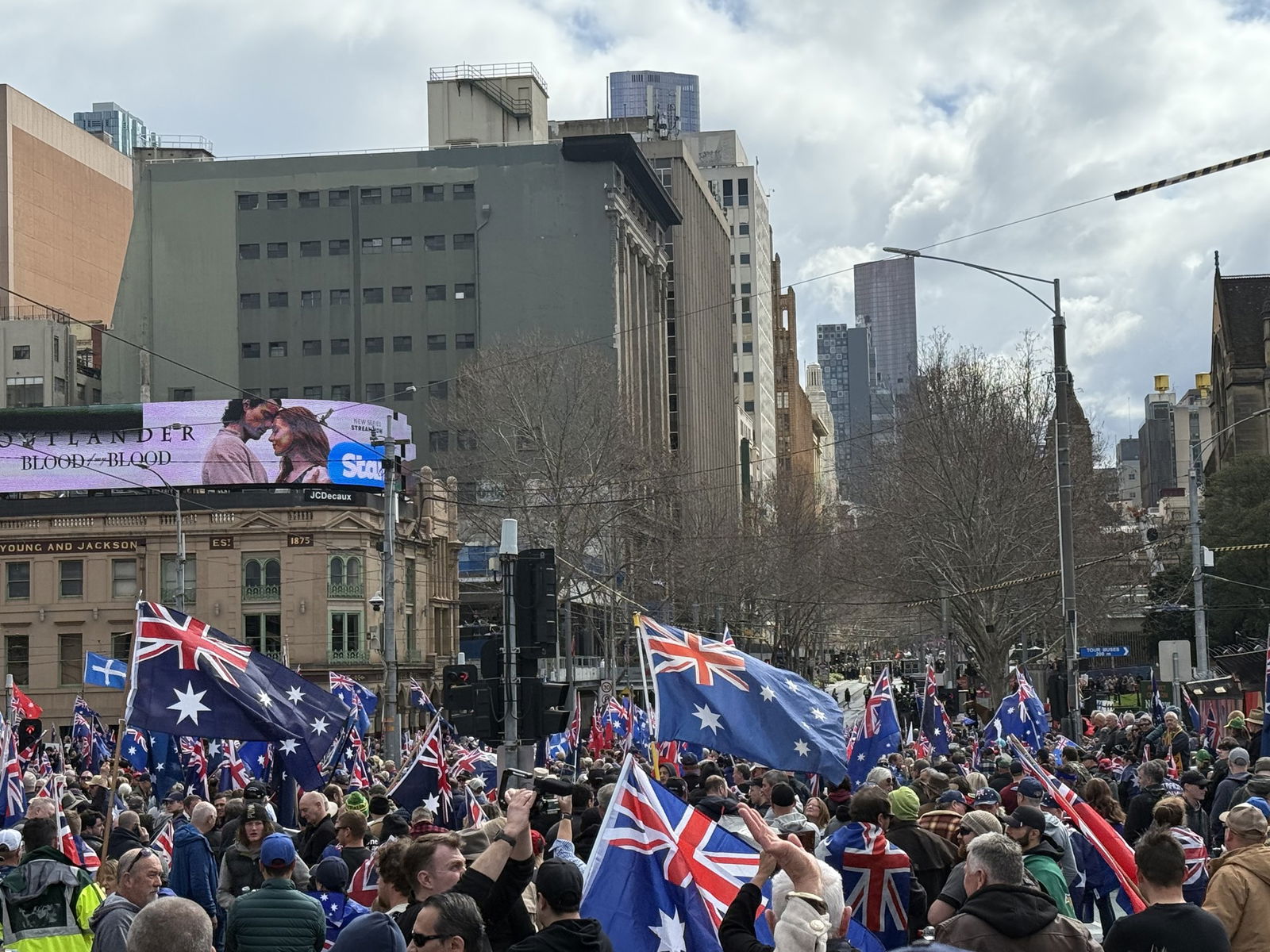 La gente agitando banderas en el CBD de Melbourne