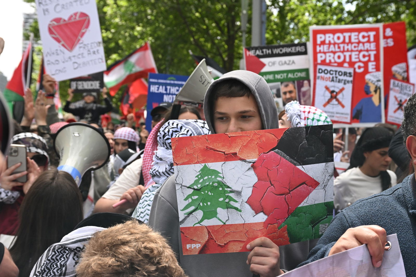 A rally with people holding pro-Palestine and Lebanon signs 