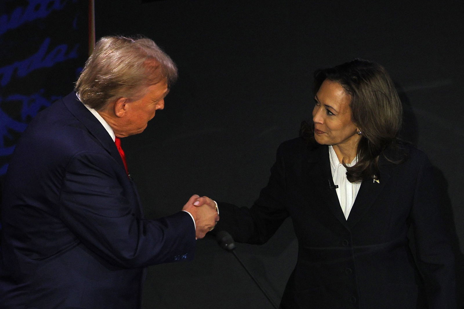 Trump and Harris shake hands.