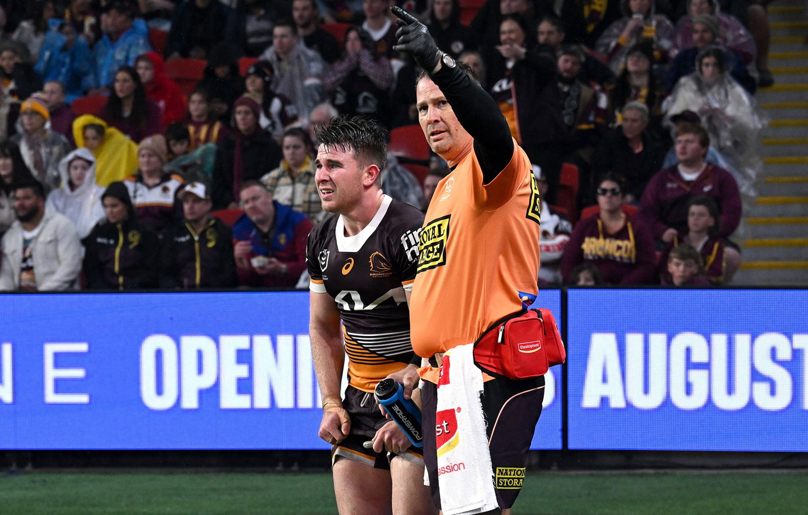 Brisbane Broncos' Jock Madden looks in pain as a trainer calls for help.