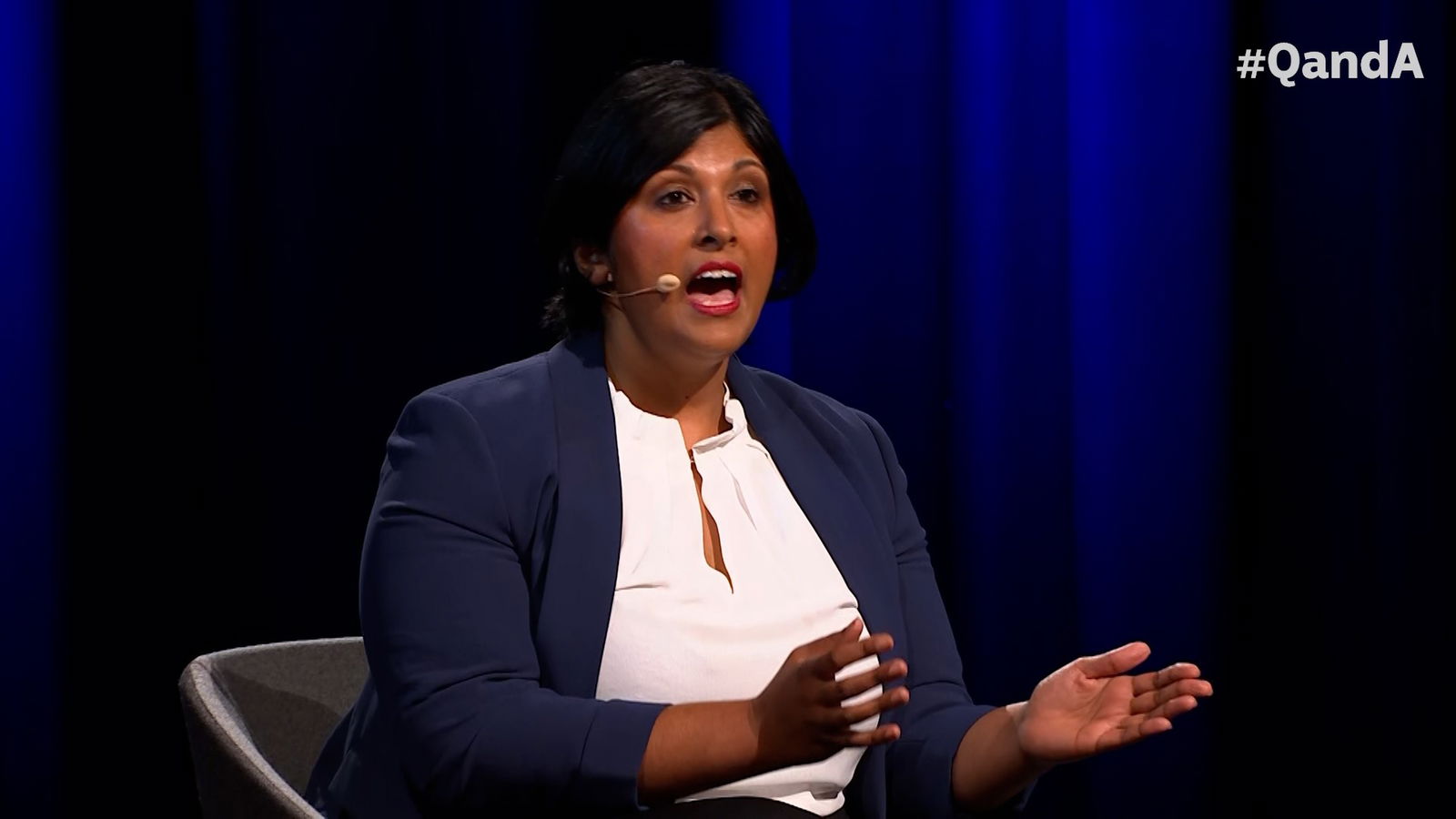 A woman in a navy suit and white shirt