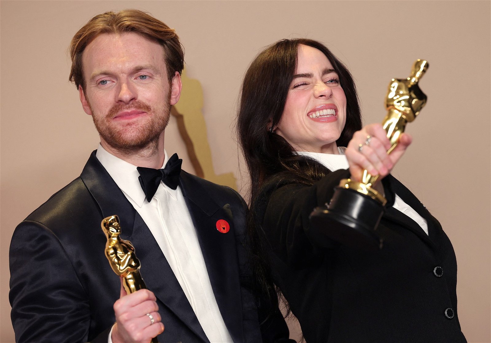 Finneas and Billie smile with their Oscars.