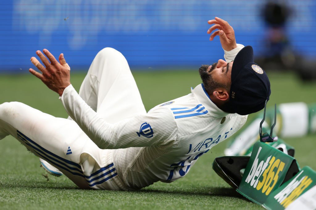 Virat Kohli rolls over the boundary as he fields.