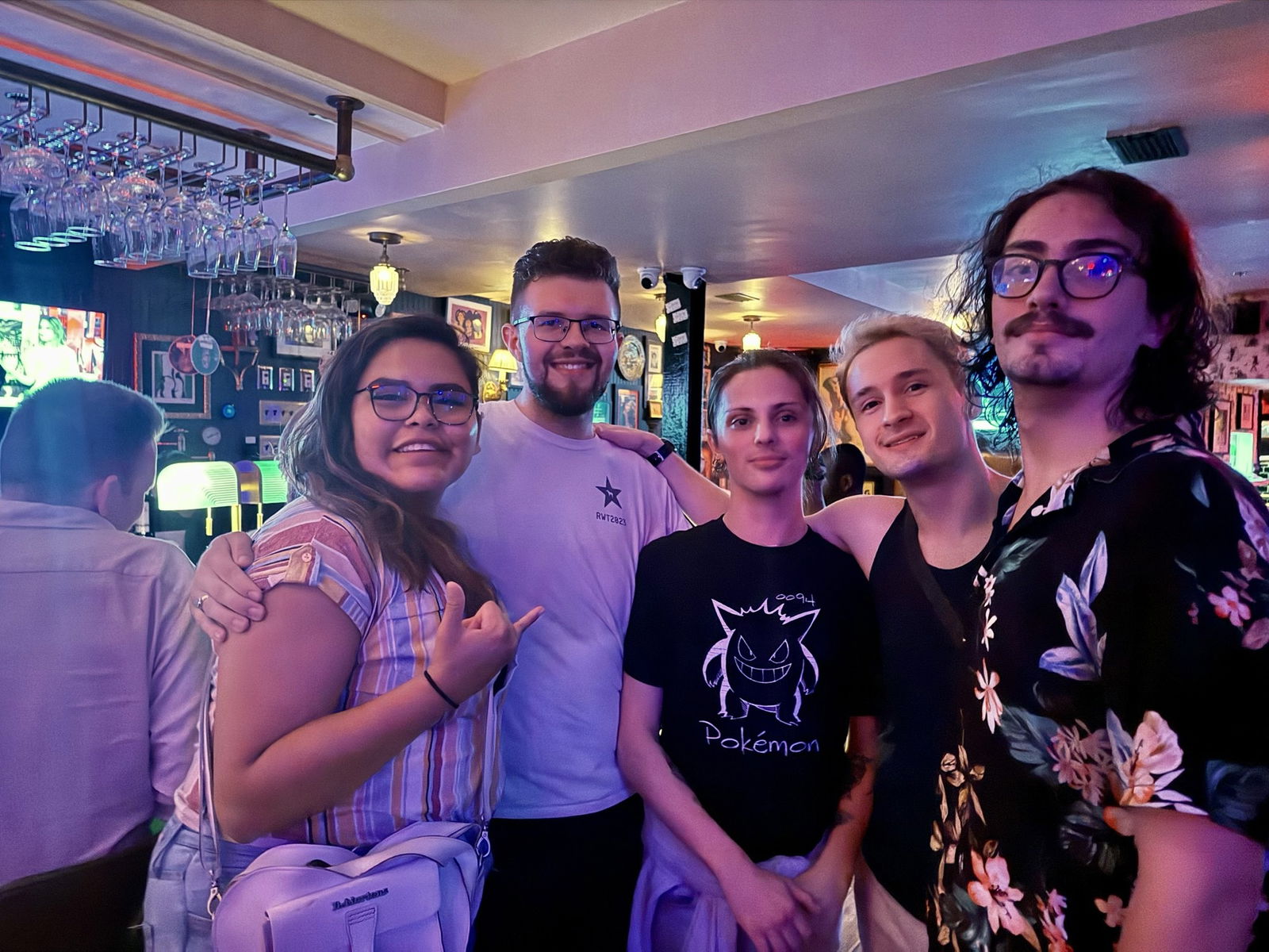 Five young people pose for a group photo in a bar