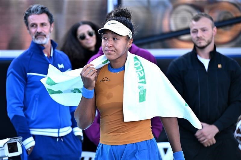 Naomi Osaka with a towel over her shoulders at a tournament.