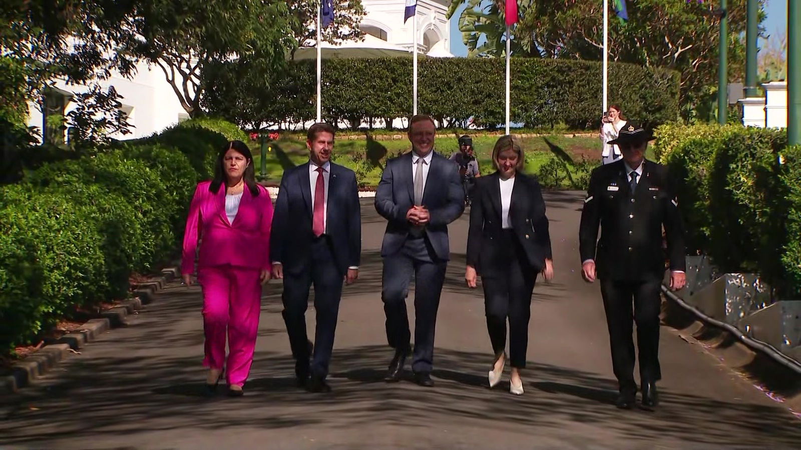 A group of politicians walk down a hill.