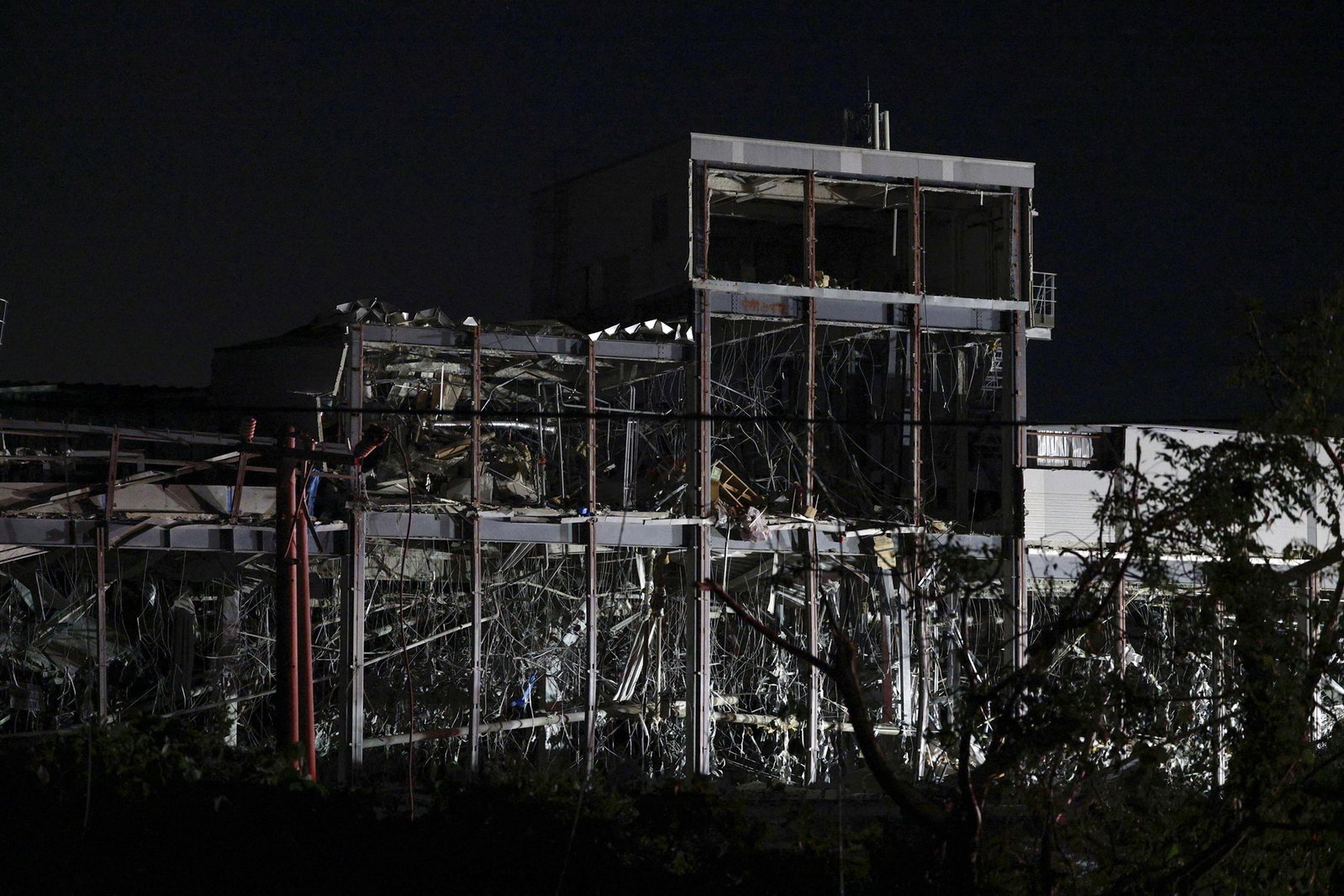 The foundation of a building standing among rubble at night.