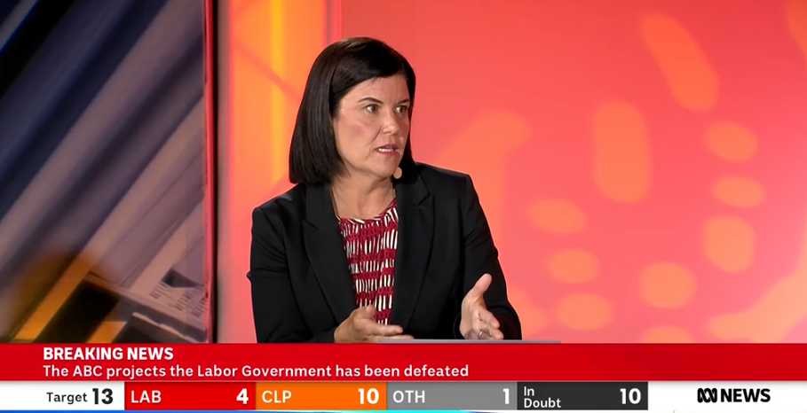 a brunette woman wearing a blazer on a panel