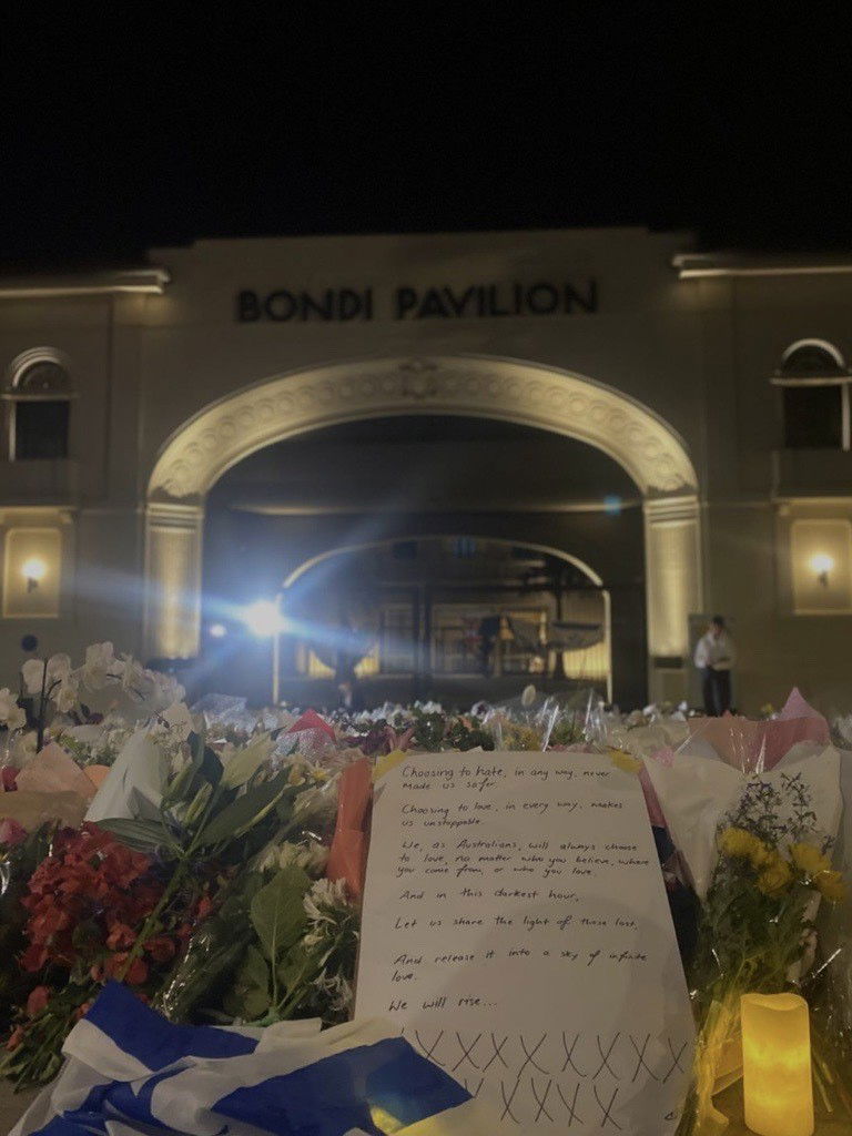Um ramo de flores com uma nota que diz: "Escolher odiar, de qualquer forma, nunca nos deixou mais seguros."Escolher amar, em todos os sentidos, nos torna imparáveis."Nós, como australianos, também escolheremos amar, não importa em quem você acredita, de onde você vem ou quem você ama."E nesta hora mais sombria,"Vamos compartilhar a luz dos perdidos,"E libere-o em um céu de amor infinito."Nós subiremos."