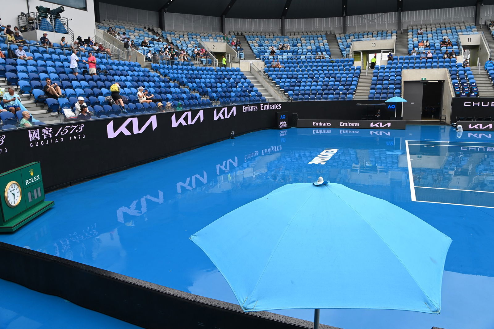 A tennis court that is wet