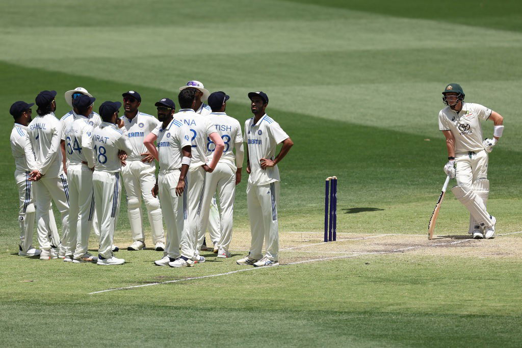 Australia batter Steve Smith waits alongside the Indian team during a DRS review in a Test.