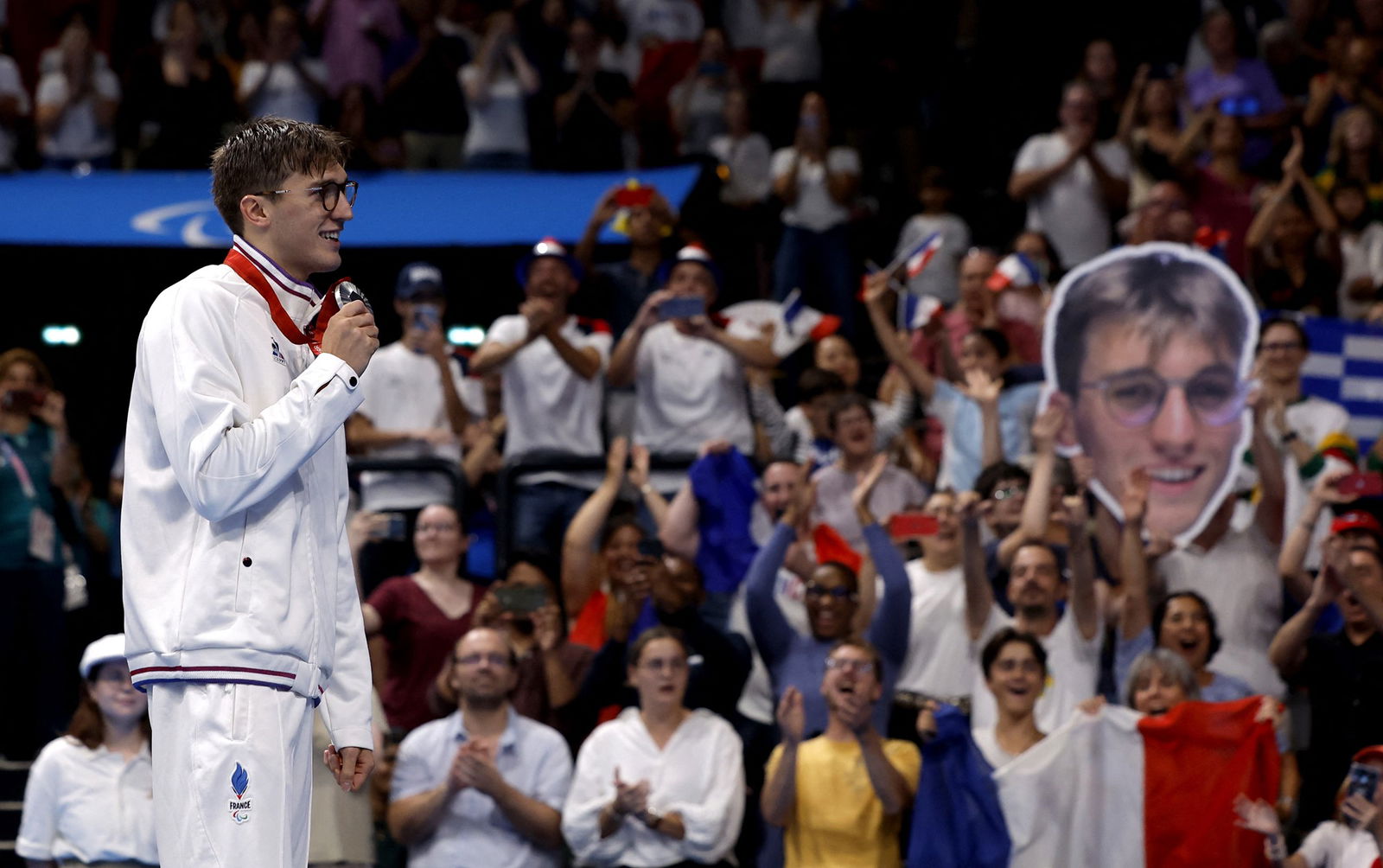 Silver medallist Alex Portal of France poses with his medal as the crowd holds up a cardboard cut-out of his face.