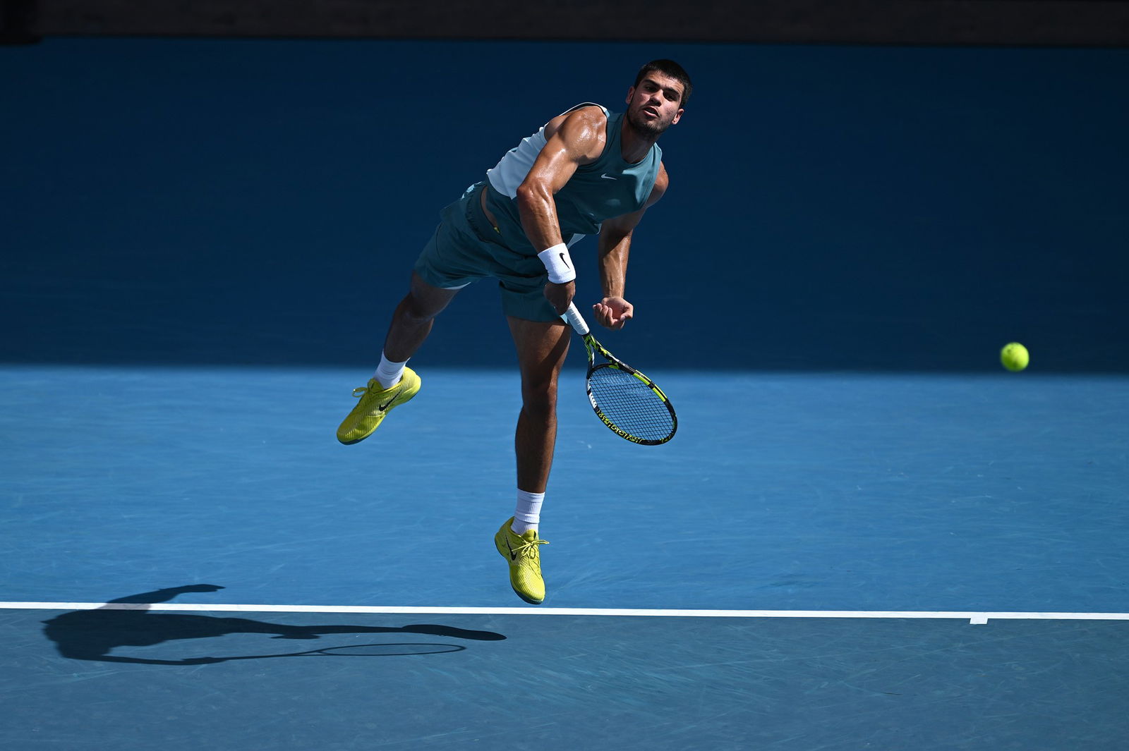 Carlos Alcarz follows through on a serve at the Australian Open