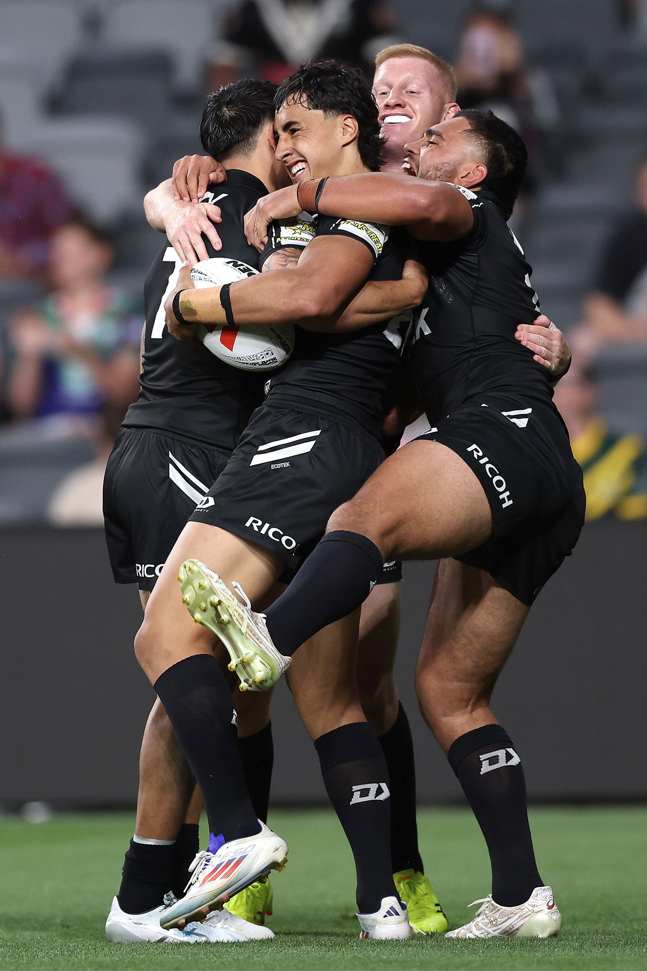 Casey McLean is hugged by Kiwis teammates.