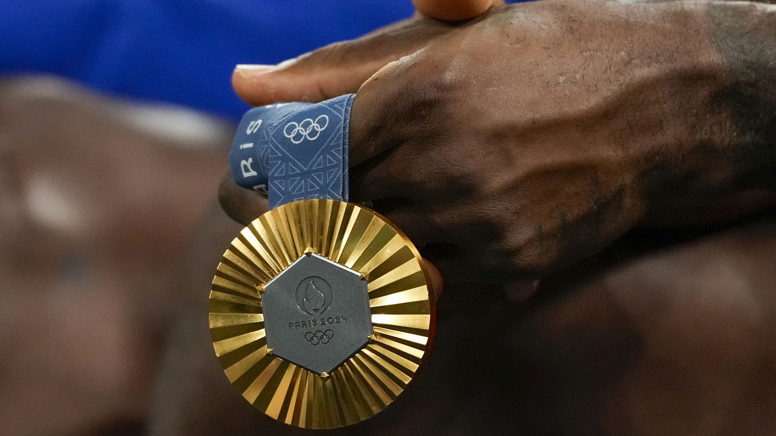 A gold medal is held by an athlete.