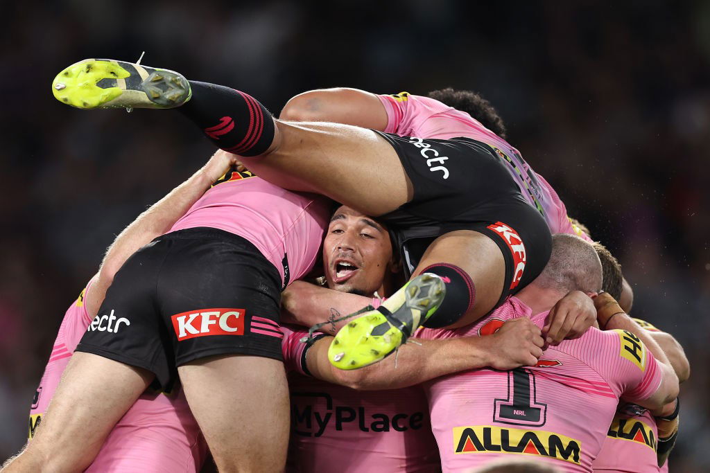 Penrith Panthers players jump on Izack Tago to celebrate during the NRL grand final.