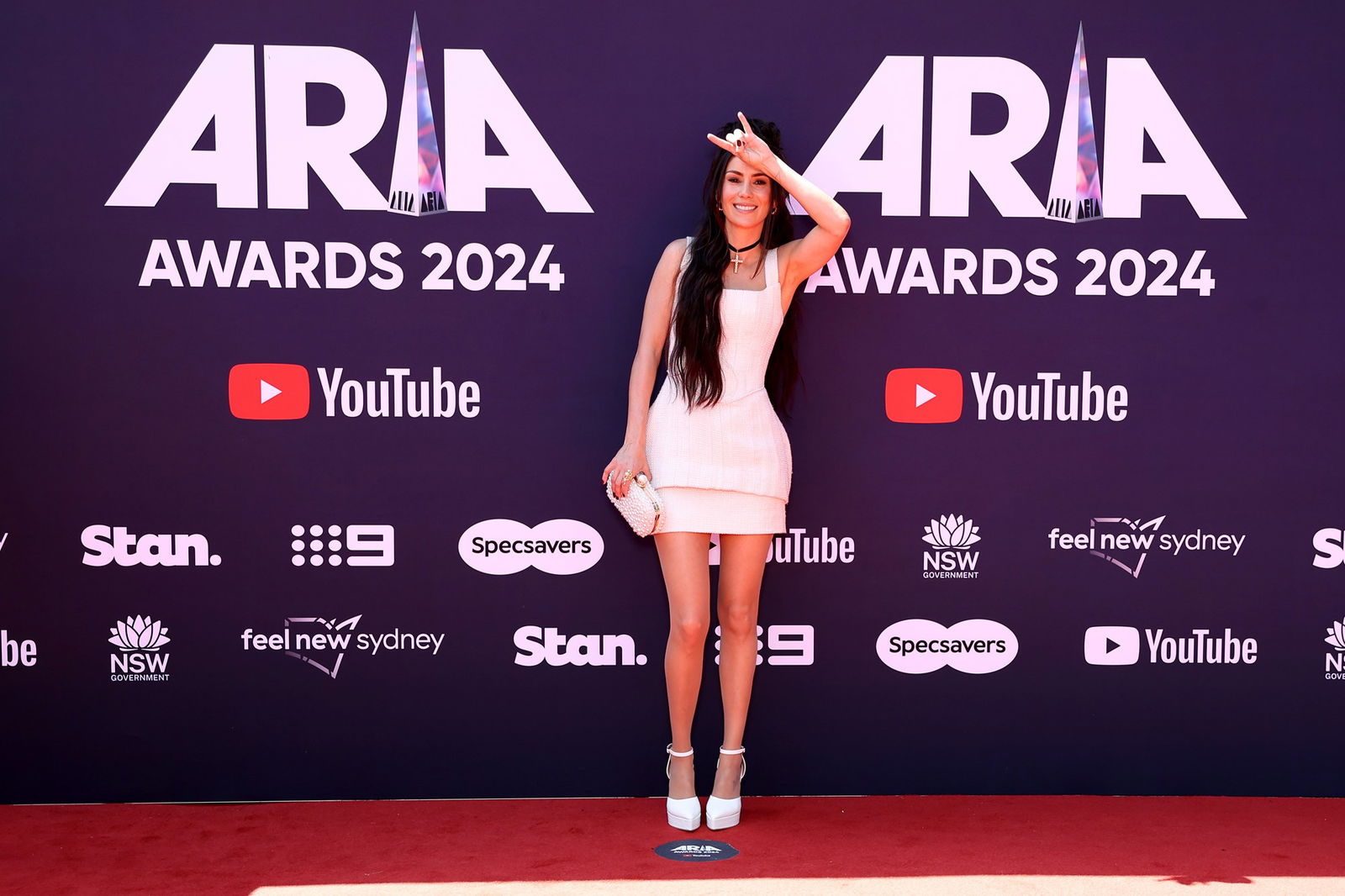 Amy Shark doing a rock sign