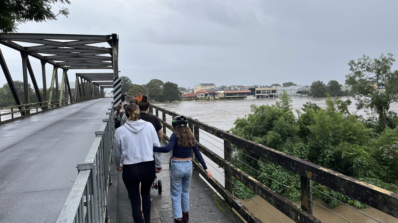 A family walks across a bridge over a river