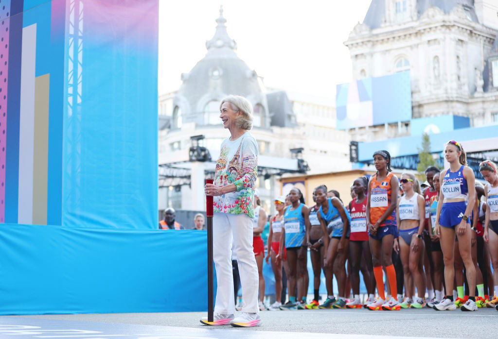 Kathrine Switzer stands in front of the women's marathon field at the start line at the Paris Olympics.