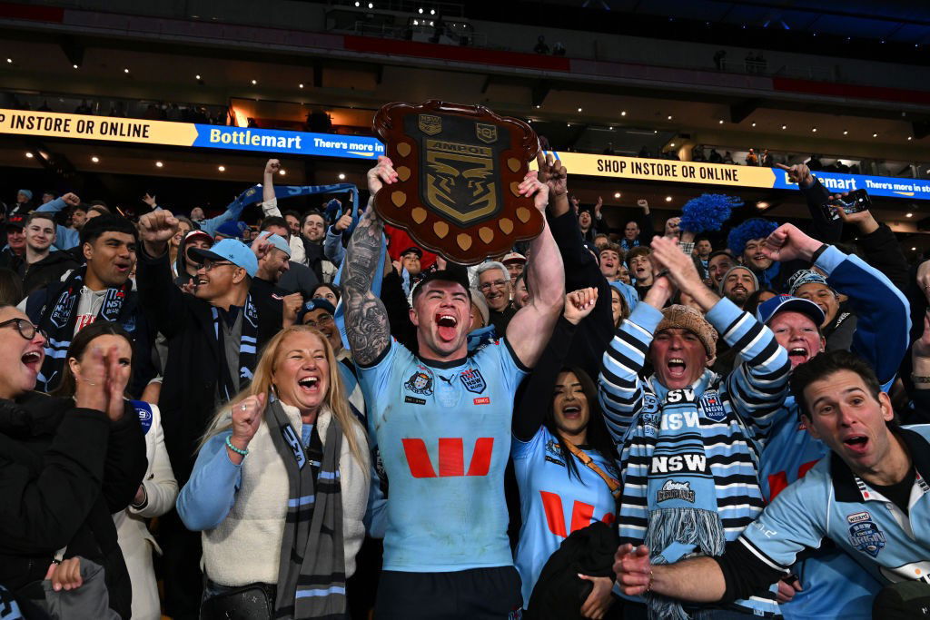 Bradman Best lifts the State of Origin shield in front of fans.