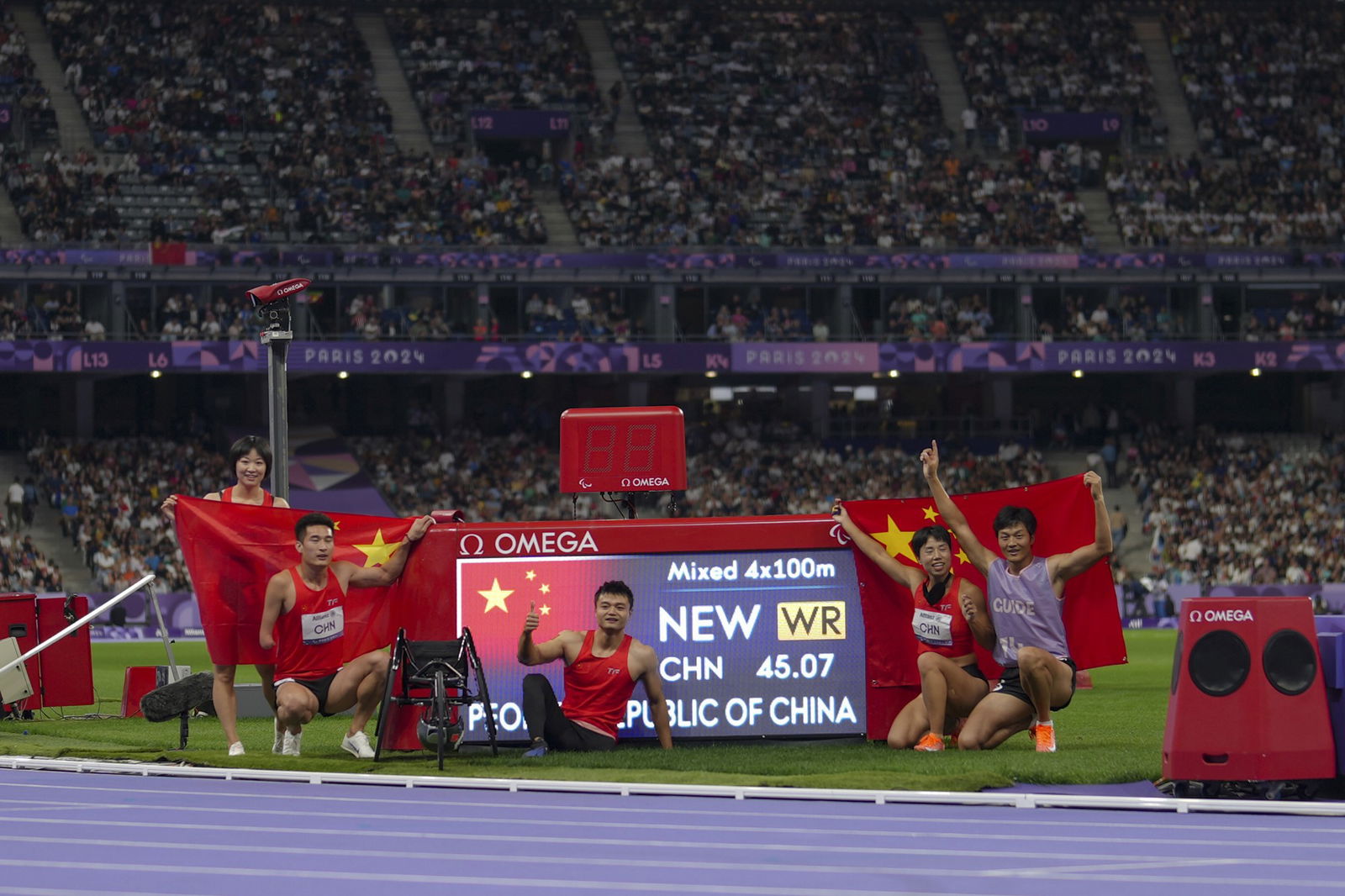 China team poses after winning the gold and setting a new world record in the 4x100 m. universal relay in para athletics at the 2024 Paralympics.