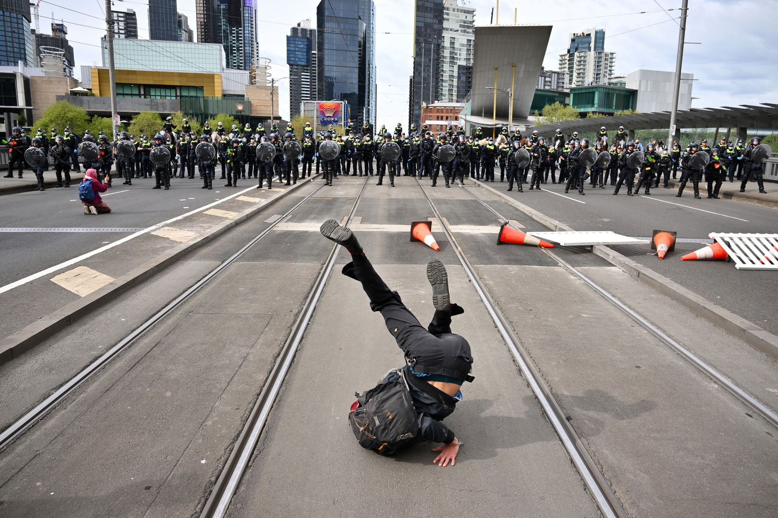 A protester strikes a pose in front of police lines.