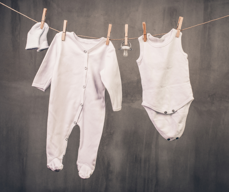 Baby clothes hung up on a laundry line.