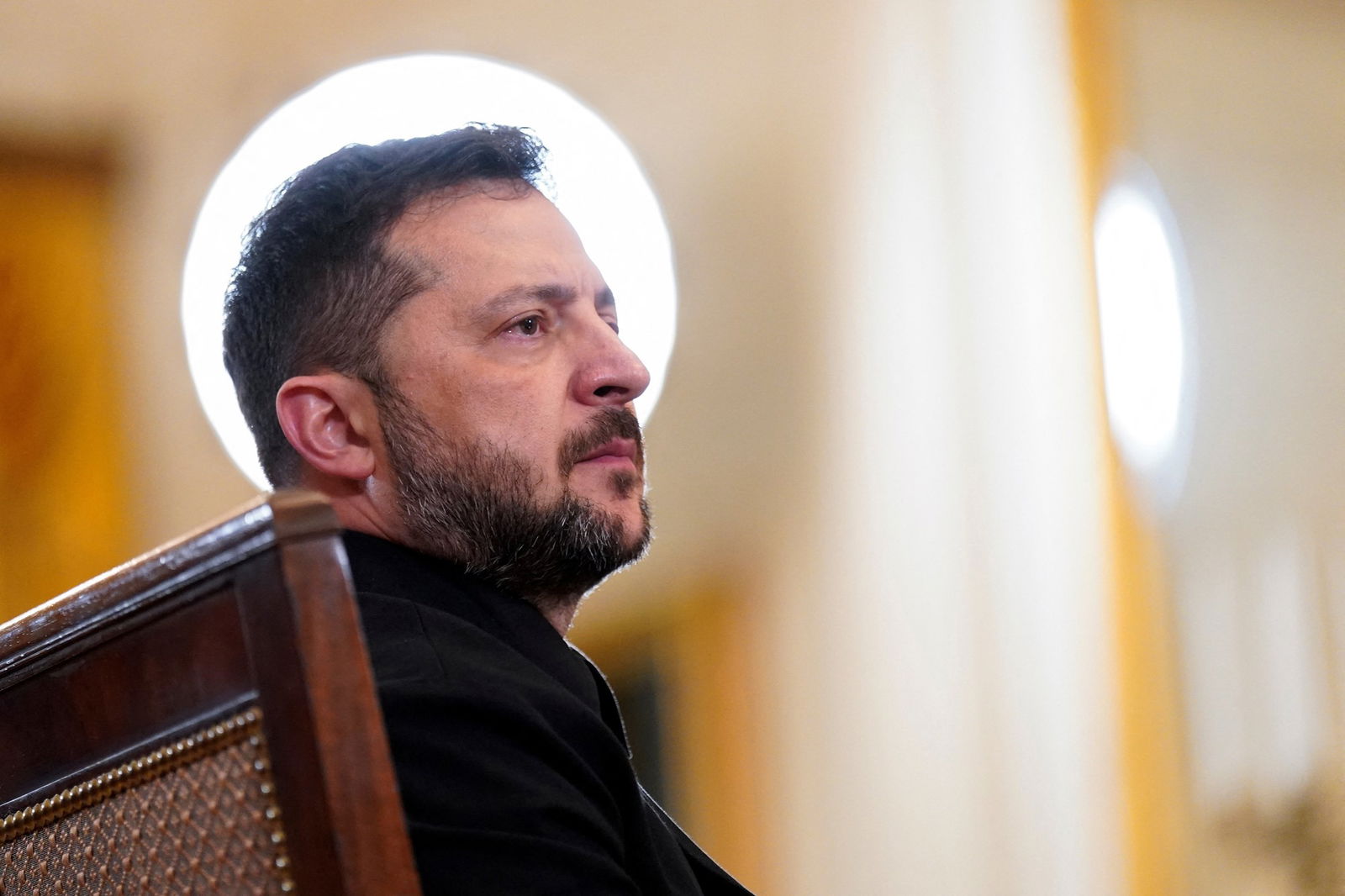 A round light shines behind Zelenskyy's head