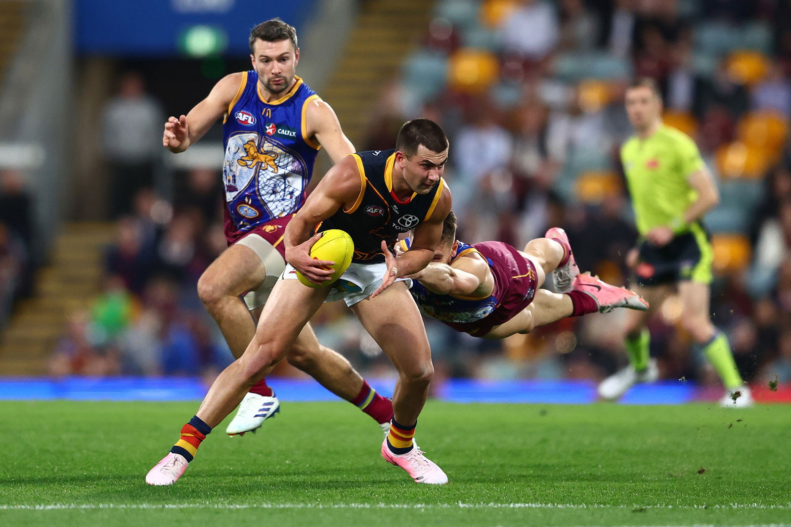 Josh Rachele no vārnām tiek risināts 17. kārtas AFL mačā starp Brisbenas Lions un Adelaidas vārnas Gabbā, 2024. gada 7. jūlijā Brisbenā, Austrālijā.