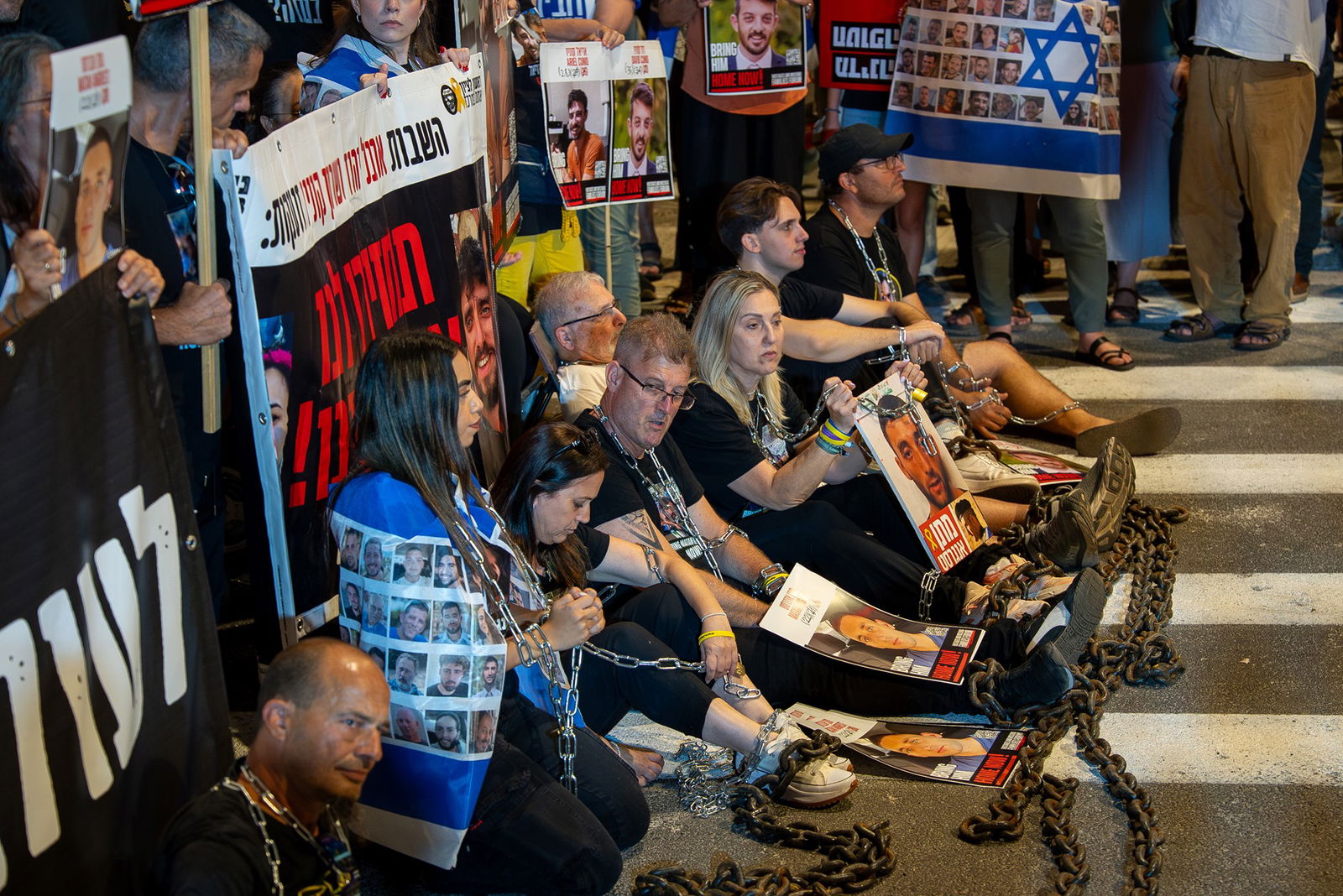 People sit on the ground in chains.