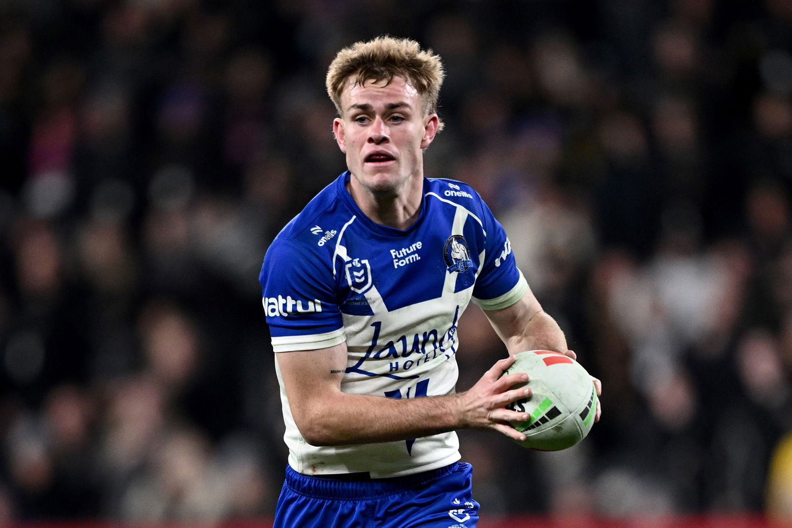 Lachie Galvin playing for the Canterbury Bulldogs, running with the ball in both hands