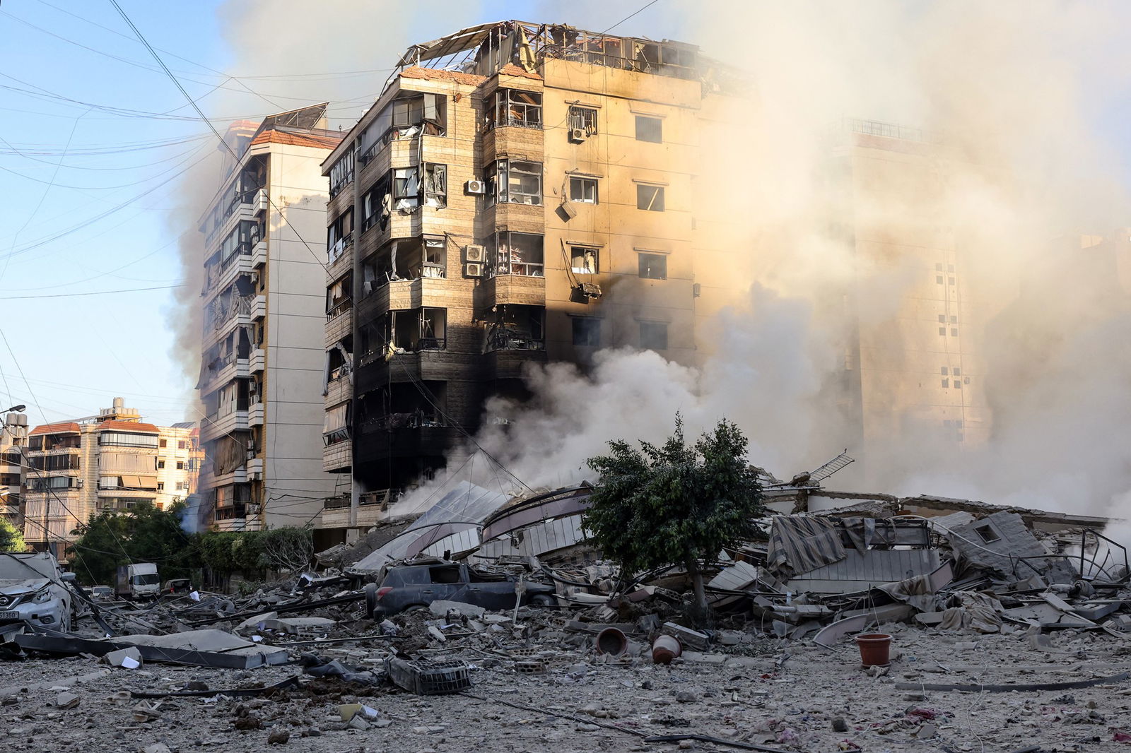 Smoke rises from the rubble of a building