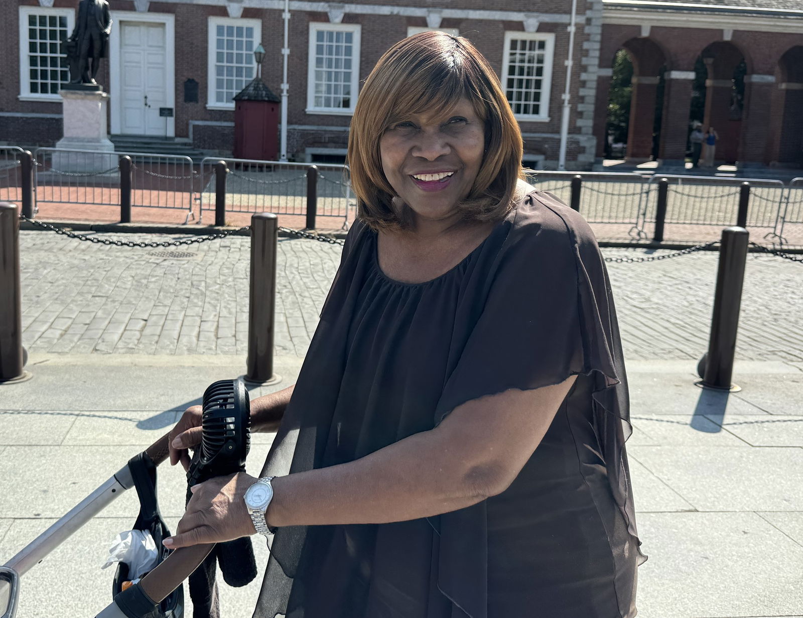 A woman smiles while pushing a pram down a Philadelphis street