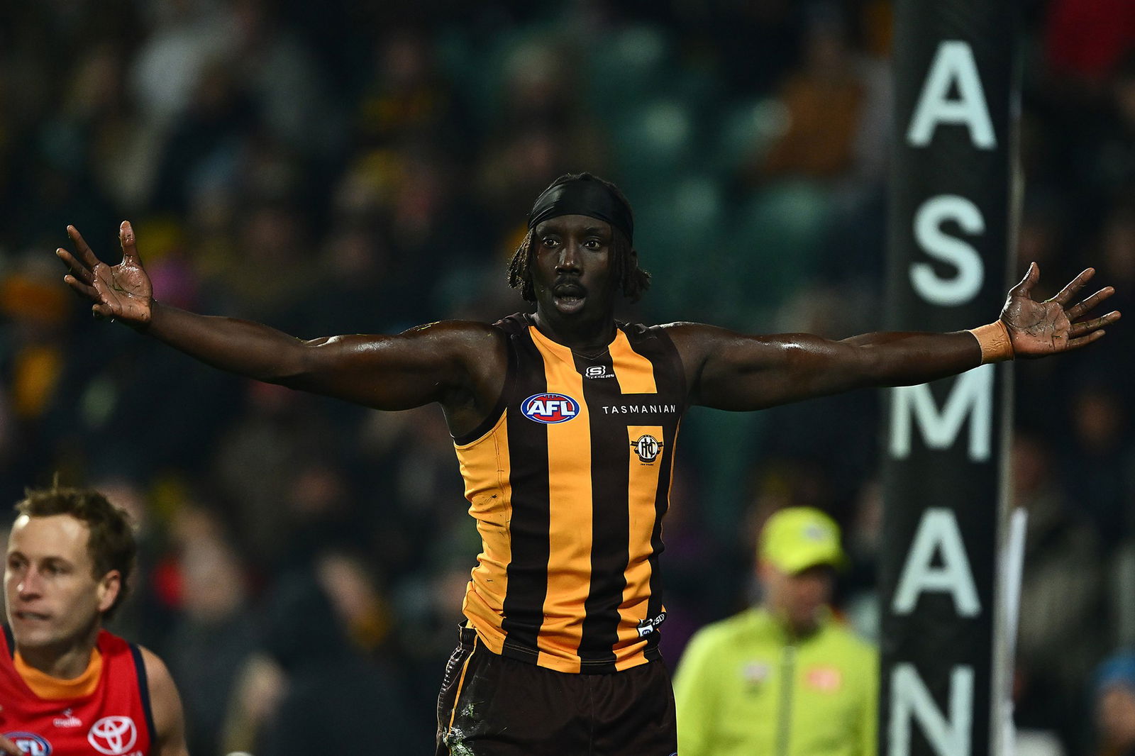 Mabior Chol stands with his arms out wide.
