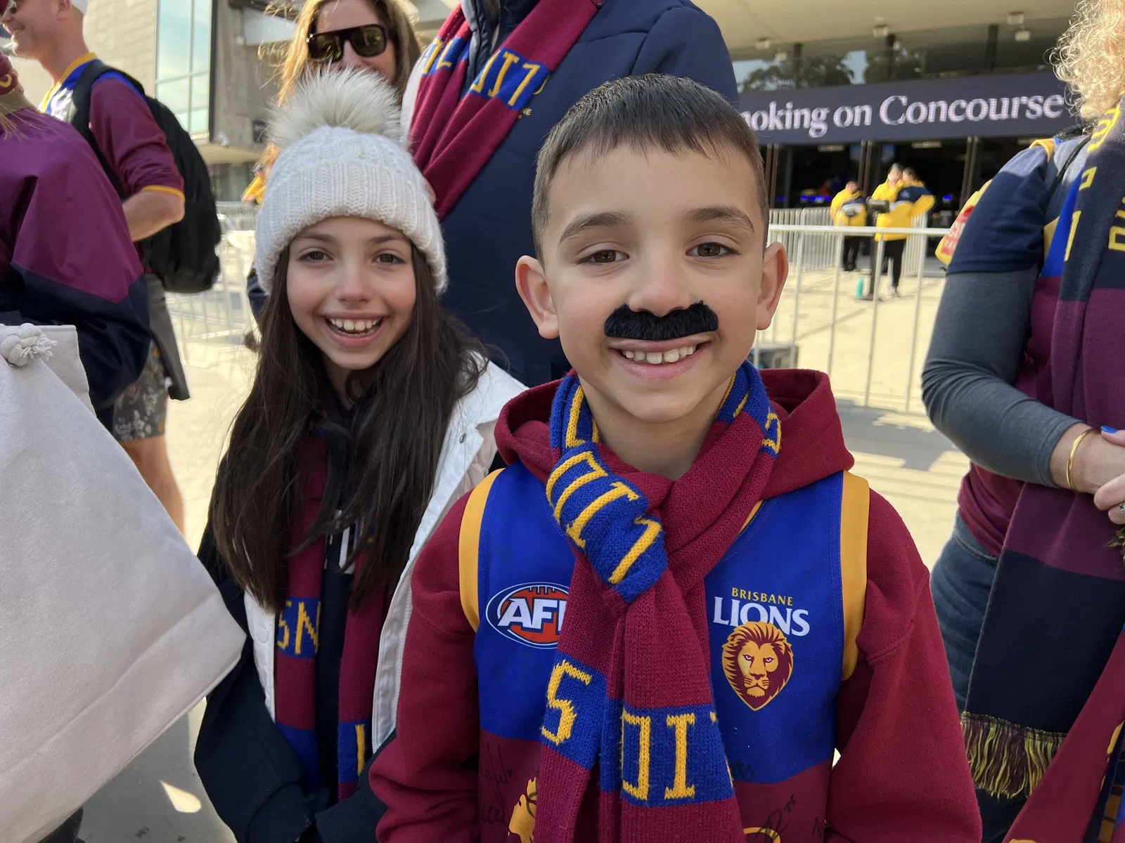 A boy and girl dressed in Brisbane Lions gear.