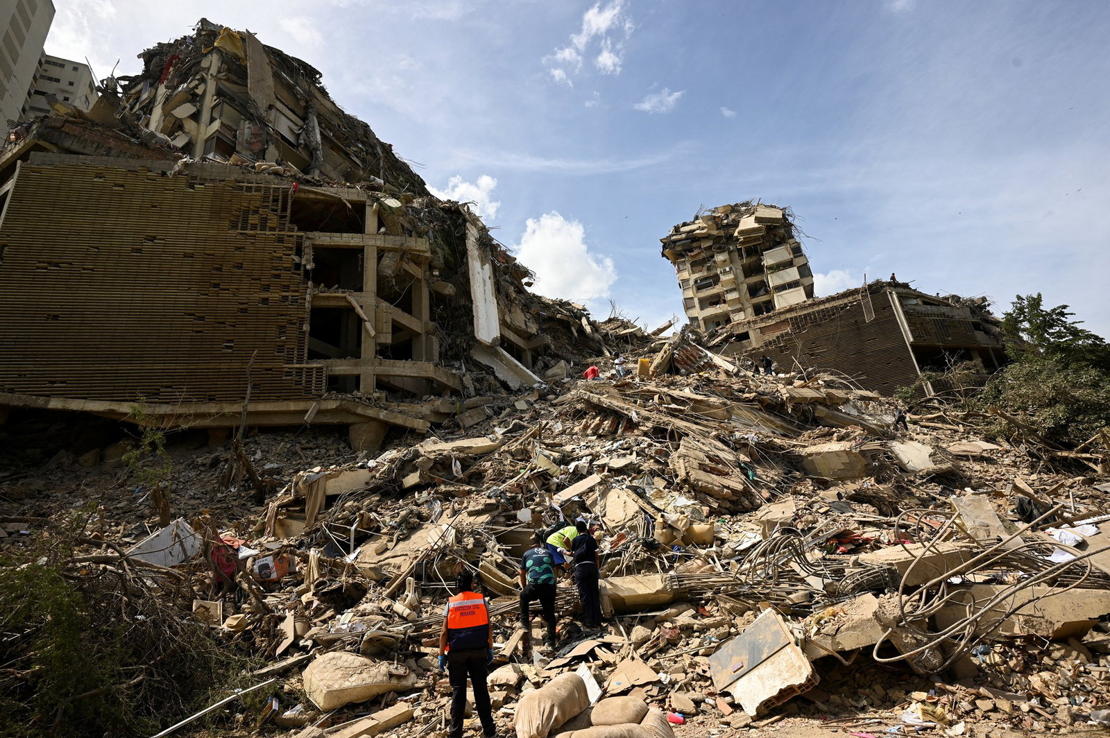 Rescue workers climb the rubble of a collapsed building 