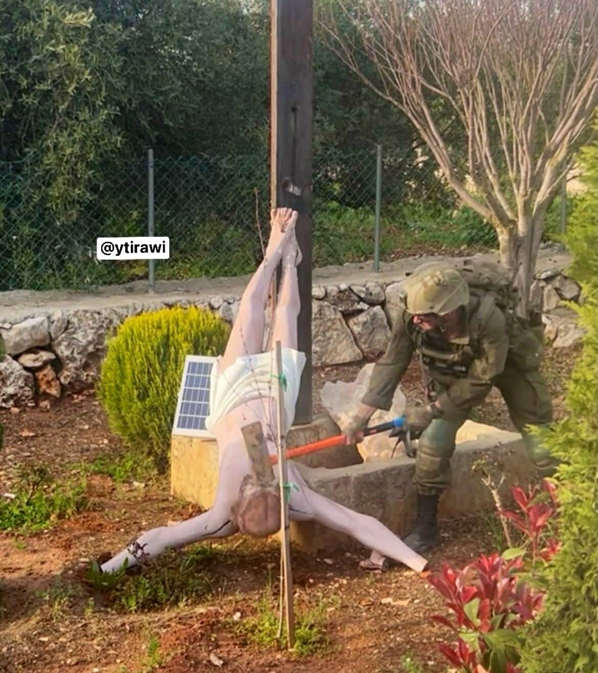 A soldier smashing a Jesus statue with a sledgehammer