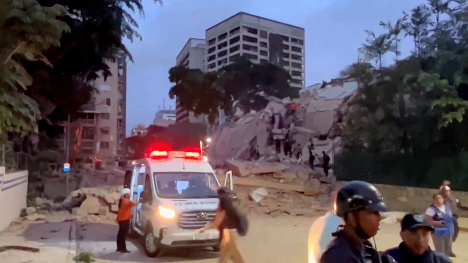 An ambulance parked outside a collapsed building