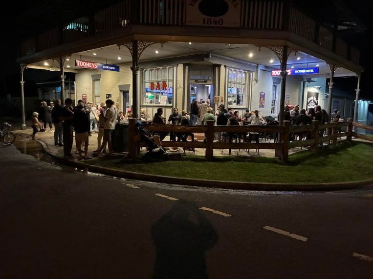 A hotel at nighttime, with lots of people out the front