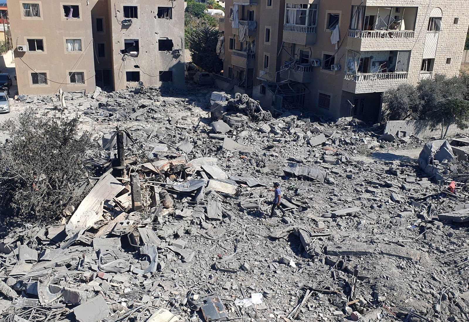 A man walks on the rubble of destroyed buildings at the site of Israeli strikes in Saksakiyeh, southern Lebanon