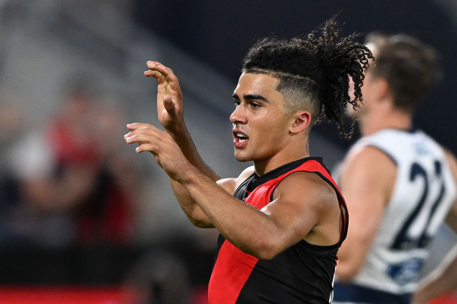 Isaac Kako raises his arms in an AFL preseason match.