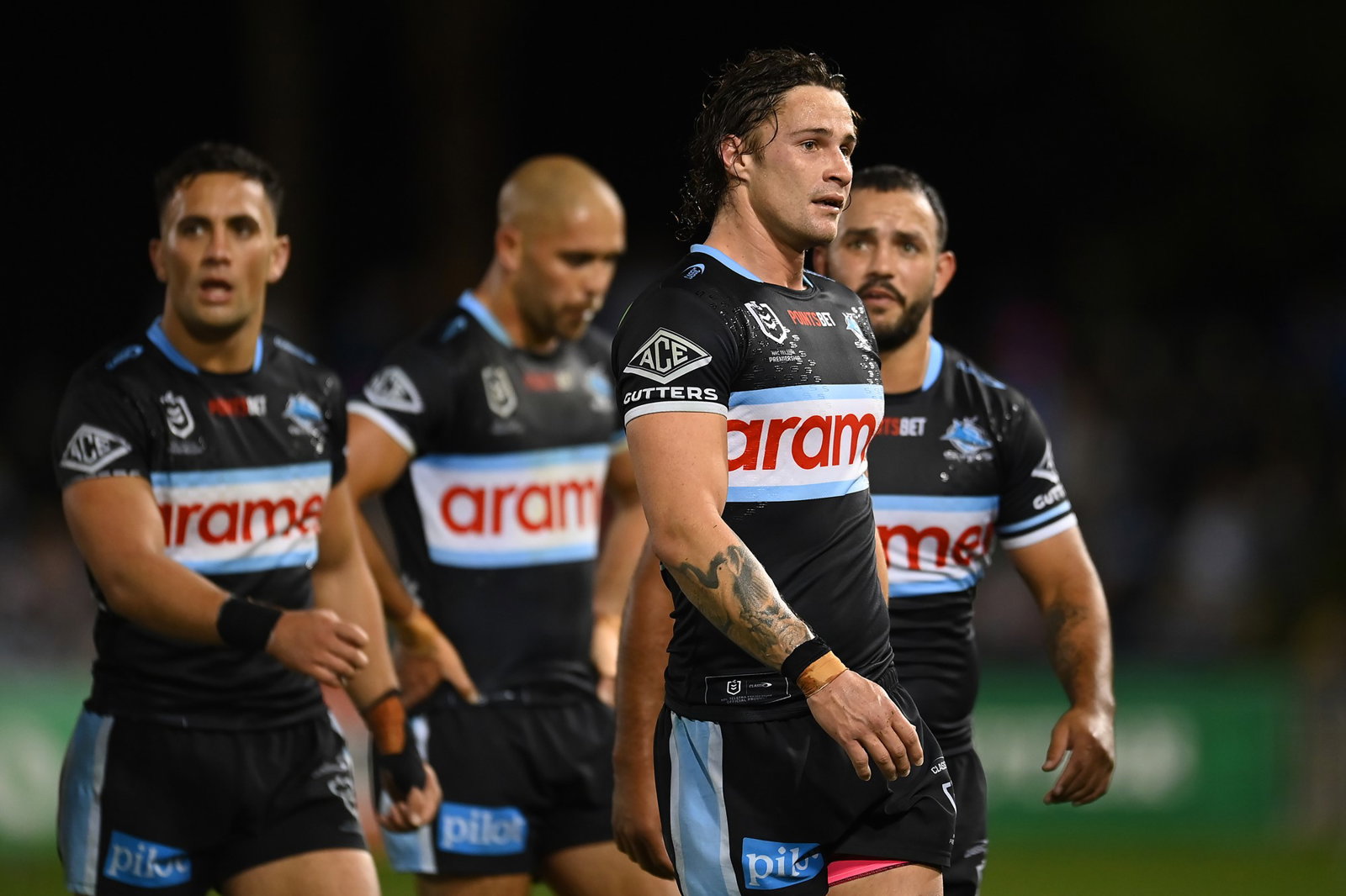 Nicho Hynes and Cronulla Sharks teammates walk off the field at half-time of an NRL game.